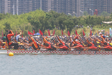 ◎ 六月十日,江西南昌九龍湖,二0二三年中國南昌國際龍舟賽開賽。本屆賽事共有來自中外四十四支龍舟隊參加,不少民眾在岸邊觀賽。(中新社記者 劉力鑫 攝)