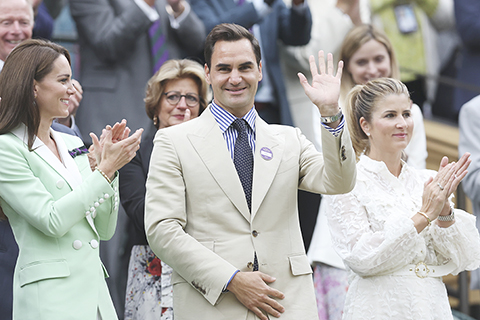 ◎ 七月四日,費達拿(前中)在看台揮手致意。當日,退役瑞士網球名將費達拿亮相溫布頓網球公開賽中央球場。(新華社記者 韓岩 攝)