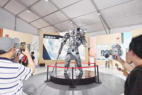 ◎ 七月二十六日,二0二三年空軍航空開放活動.長春航空展在吉林長春開幕。此次航空展共設置空軍主題館、航空航天文創科普體驗館、沉浸式體驗館等六個室內展館,讓參觀者「沉浸式」體驗航空樂趣。圖為參觀者拍攝文創產品。(中新社記者 張瑤 攝)