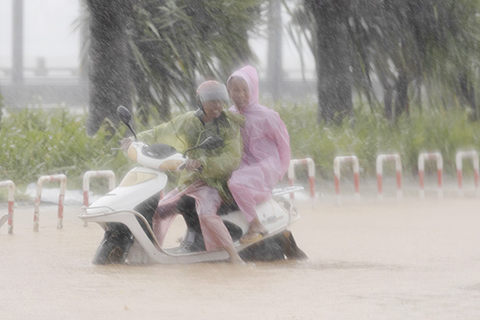 ◎ 七月二十八日,福建泉州,民眾冒風雨出行。當日九時五十五分,今年第五號颱風「杜蘇芮」在福建泉州晉江沿海登陸,中心附近最大風力十五級,為強颱風級。(中新社記者 王東明 攝)