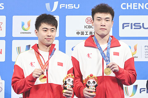 ◎ 七月三十一日,中國組合黃博文(左)/梁超輝展示金牌。在成都舉行的第三十一屆世界大學生夏季運動會男子雙人三米跳板決賽中,中國組合黃博文/梁朝輝以三百九十七點三五分的成績奪得冠軍。(新華社記者 劉坤 攝)
