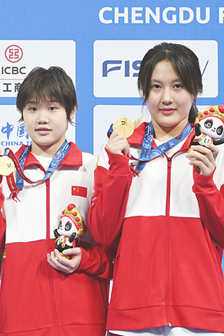 ◎ 七月三十一日,張家齊(左)/掌敏潔在頒獎儀式上,在成都舉行的第三十一屆世界大學生夏季運動會女子雙人十米跳台決賽中,中國組合張家齊/掌敏潔以三百四十九點零八分的成績奪得冠軍。(新華社記者 劉坤 攝)