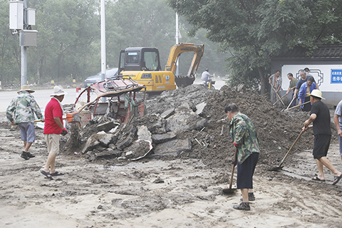 ◎ 八月二日,北京市門頭溝區,琉璃渠村內的道路清淤作業有序進行。(中新社記者 趙隽 攝)