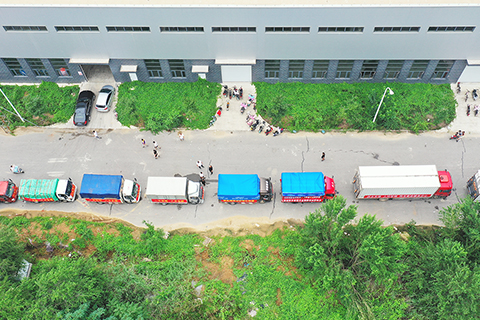 ◎ 八月五日,在河北省涿州市鋼研物資儲備點外,運送物資的車輛排起了長隊(無人機照片)。當日,大批來自全國各地的捐贈物資運抵河北涿州,支援當地受災群眾。(新華社記者 牟宇 攝)
