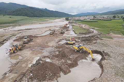 ◎ 八月六日,工程車輛正在搶修損毀公路。(無人機照片)(中新社記者 蒼雁 攝)