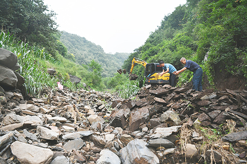 ◎ 河北省邢台市臨城縣趙莊鄉梁家莊村,一個太行山深處的小山村,是此次強降雨過程中河北最大降雨點,七月二十九日八時到八月一日七時,累計降雨量突破一千毫米。常住人口一百一十二人的梁家莊經受住了極值暴雨考驗,無一人傷亡。圖為八月九日,村民在梁家莊村一條正在修復的田間道路上清理碎石。(中新社記者 翟羽佳 攝)