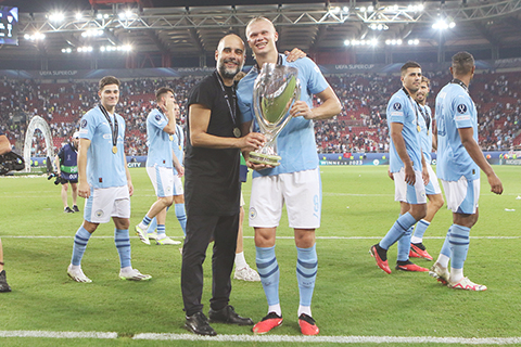 ◎ 八月十六日,曼城隊主教練哥迪奧拿(前左)與夏蘭特在比賽後與獎盃合影。(新華社發)