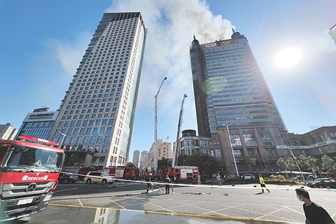 ◎ 八月二十二日,天津南開區萬德莊街新天地大廈外牆起火,市應急、消防等部門迅速趕到現場,全力投入滅火和人員疏散工作。目前火情已基本得到控制,相關部門仍在緊張工作中。(中新社記者 佟郁 攝)