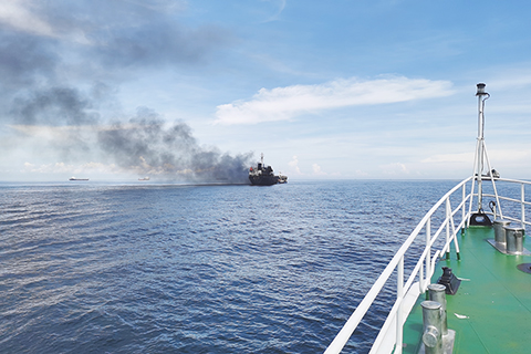 ◎ 一艘裝載有六千八百五十八噸柴油的油輪在廣西欽州港外錨地著火。船上十五人獲救,二名船員遇難。目前,海上防污染工作正在有序進行,事故原因仍在調查中。圖為事故油輪冒出濃煙。(中新社發 廣西欽州海警 供圖)