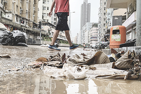 ◎ 九月八日,大雨過後,香港深水埗街頭滿佈泥濘,市民需一腳深一腳淺地小心出行。大埔道往旺角方向,垃圾被沖到馬路上,佔據了一條行車線,雙車道變成一車道。(香港中通社記者徐文峰 攝)
