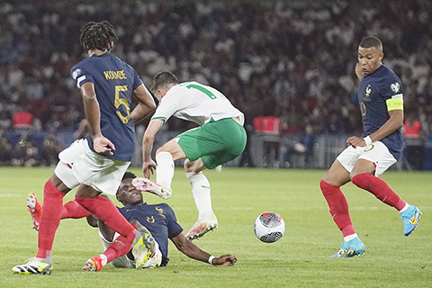 ◎ 二0二四年歐國盃足球小組賽,九月七日在巴黎王子公園球場舉行,法國隊奧雷利安.喬阿梅尼(5)與愛爾蘭的詹姆斯.麥克萊恩(11)爭搶,右為法國隊虎將麥巴比。(美聯社)