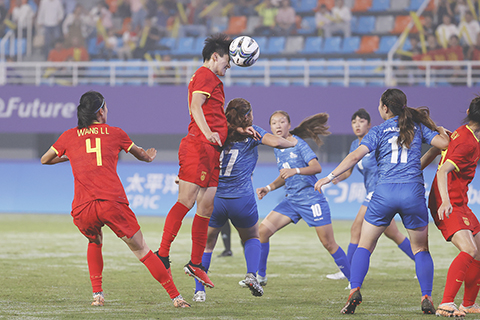 ◎ 九月二十二日,中國隊球員王珊珊(上)在比賽中頭球攻門。第十九屆亞運會女子足球小組賽A組比賽在浙江杭州舉行,中國隊十六比0勝蒙古國隊。(中新社記者 殷立勤 攝)