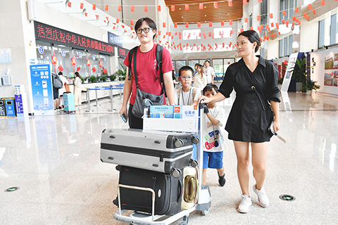 ◎ 九月二十九日,正值中秋佳節,三十三位台胞台屬通過「台陸通」公共信息服務平台購買了海空聯運套票,在福州馬尾琅岐碼頭搭乘當天十二時三十分的福(州)馬(祖)「小三通」航線航班返台過中秋。圖為台胞何奕興(左)一家經福馬「小三通」回台灣過中秋。(中新社記者呂明 攝)