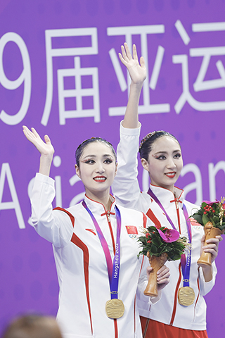 ◎ 十月七日,杭州第十九屆亞運會花樣游泳雙人自由自選比賽在杭州奧體中心游泳館結束。結合技術自選成績,中國雙胞胎組合王柳懿/王芊懿(左)以五百二十六點八六二分的總成績奪得雙人項目比賽冠軍。(中新社記者杜洋 攝)