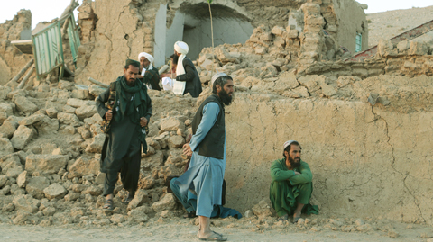 ◎ 十月七日,人們在阿富汗赫拉特省坍塌的房屋旁等待。 據中國地震台網測定,阿西北部七日下午先後發生兩次六點二級地震,震源深度均為十公里。新華社發(馬沙勒攝)