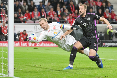 ◎ 十月廿一日,拜仁慕尼黑隊球員簡尼(右)在比賽中射門得分。當日,在德國足球甲級聯賽第八輪比賽中,拜仁慕尼黑隊客場以三比一戰勝美因茨隊。(新華社發 烏爾里希.胡夫納格爾 攝)