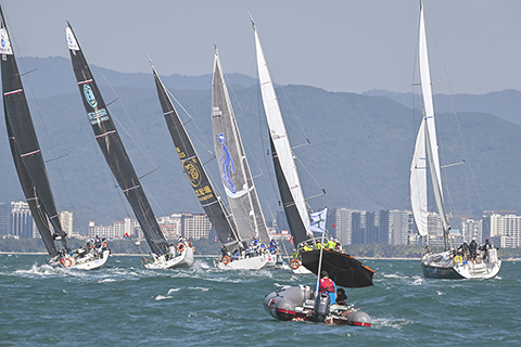 ◎ 十一月二十四日,海南三亞.參賽船隊進行三亞港內賽角逐。當日,二0二三第十二屆環海南島國際大帆船賽在海南省三亞市三亞灣附近海域場帆開賽。本屆海帆賽共有二十四支帆船隊伍約三百人參賽,設置了IRC1-3組級Dubois50組共四個組別,其中IRC1組與Dubois50組參賽三亞—海口—三亞的全環海南島拉力賽,IRC2組與IRC3組參加三亞—萬寧往返拉力賽。(中新社記者 駱雲飛 攝)