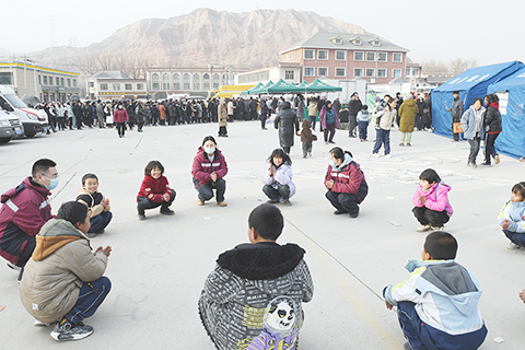 ◎十二月十九日,甘肅省第二人民醫院心理救援隊對積石山縣受災嚴重的大河家鎮、石源鎮、劉集鄉的受災民眾開展心理援助工作。北京時間十二月十八日二十三時五十九分,甘肅省臨夏州積石山縣發生六點二級地震,震源深度十公里。圖為心理救援隊隊員在大河家鎮與小朋友一起玩遊戲進行心理疏導。(中新社記者 戴文昌 攝)