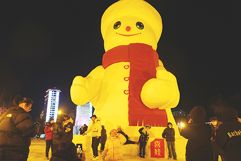 ◎ 十二月三十一日,第十三屆中國.伊春森林冰雪歡樂季在伊春市烏翠區烏馬河冰雪童話樂園開幕。正值元旦假期,不少市民前往烏馬河冰雪童話樂園觀看煙花、雪雕等,迎接新一年的到來。圖為小朋友紛紛在大雪人前合照。(中新社)