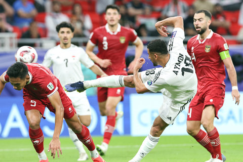 ◎ 一月十五日,伊拉克隊球員艾曼.侯賽因(中)對印尼隊射門並取得進球。伊拉克隊三比一戰勝印度尼西亞隊。(新華社記者 丁汀 攝)