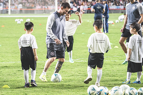 ◎ 二月三日傍晚,正在香港訪問的邁阿密國際足球隊在香港大球場進行公開訓練,球隊中的阿根廷著名球星梅西與隊友一起亮相,並與受邀參加當天公開訓練活動的少年兒童互動交流。梅西所在的邁阿密國際隊將於二月四日在香港大球場與特邀的中國香港球隊進行表演賽。圖為梅西(中)和少年兒童進行互動。(中新社記者侯宇 攝)