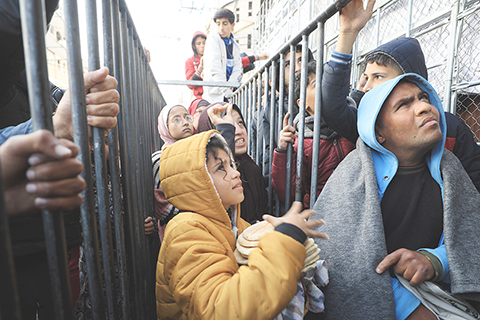 ◎ 2月19日,巴勒斯坦人在加沙地帶南部城市拉法等待購買食物。(新華社發 亞西爾·庫迪 攝)