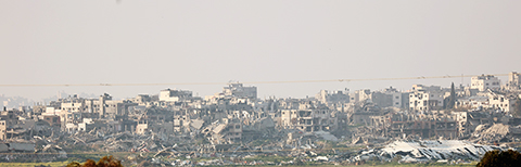 ◎ 這是二月廿五日在加沙邊境以色列一側拍攝的加沙地帶建築遭襲的情況。 據巴勒斯坦電視台當日報道,以色列軍隊當天轟炸加沙地帶北部和南部多個地區,造成至少四十八人死亡。新華社發(吉爾.科恩.馬根 攝)