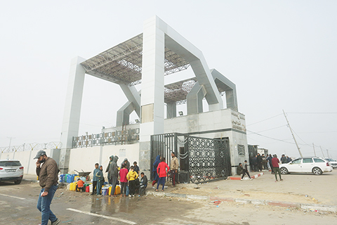 ◎ 二月廿五日,人們在拉法口岸加沙一側等待前往埃及。新華社發(哈立德.奧馬爾 攝)