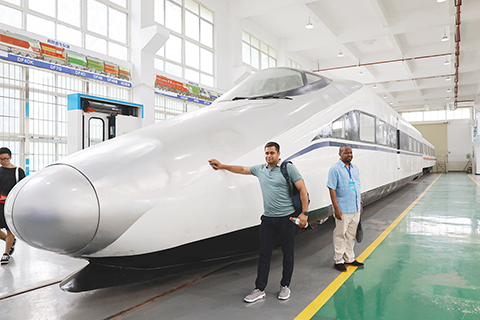 ◎ 五月二十二日,來自老撾、馬來西亞等十二個共建「一帶一路」國家的二十九名官員,齊聚廣西柳州市柳州鐵道職業技術學院,參與全球發展倡議下經濟走廊建設發展與互聯互通合作研修班。該研修班為學員提供一個全面了解中國鐵路、了解中國職業教育發展,相互學習交流的機會。圖為學員「打卡」中國高鐵。(中新社)