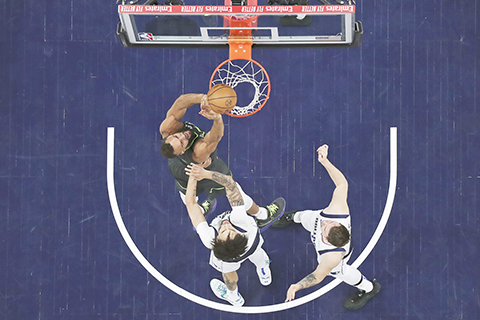 ◎ 五月三十日,在明尼阿波利斯舉行的NBA籃球西部聯盟決賽第五場比賽的上半場,明尼蘇達木狼隊中鋒魯迪.高拔(左上)投籃,達拉斯小牛隊中鋒德雷克.萊費利和後衛盧卡.當錫(右)予以封阻。(美聯社/馬特.克羅恩)