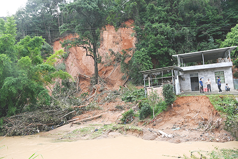 ◎ 福建省龍岩市武平縣各級各部門紛紛深入受災嚴重的鄉鎮,與當地民眾一起爭分奪秒開展災後自救互救。自六月十六日遭遇破歷史極值特大暴雨以來,武平多地受災嚴重。圖為前往中赤鎮的沿途路上,多處山體滑坡。(中新社記者 張金川 攝)