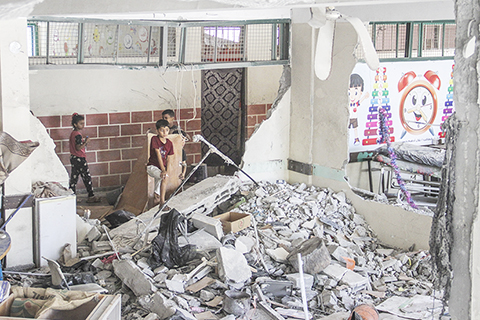 ◎ 據巴勒斯坦通訊社六月二十五日報道,以色列軍隊當天早晨襲擊加沙地帶北部加沙城多處地點,造成至少十八人死亡,另有多人受傷。圖為當日,巴勒斯坦兒童查看加沙城西部沙提難民營一所以軍轟炸的學校。(新華社發馬哈茂德.扎基 攝)