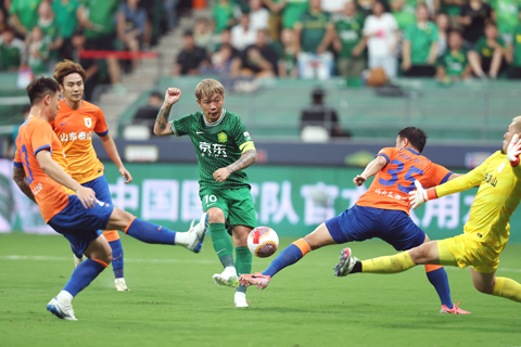 ◎ 六月三十日,北京國安隊球員張稀哲(中)在比賽中射門。中國足球協會超級聯賽第十七輪比賽中,北京國安隊主場二比0勝山東泰山隊。(新華社記者賈浩成攝
