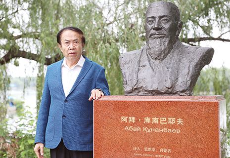 7月2日,袁熙坤與其創作的阿拜·庫南巴耶夫的雕像合照。(中新社記者 李國慶 攝)