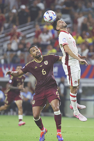 ◎ 七月五日,在德克薩斯州阿靈頓舉行的委內瑞拉合加拿大之間的美洲杯四分之一決賽足球比賽中,加拿大中場喬納森•奧索里奧(右)頭槌頂贏委內瑞拉中場揚格爾·埃雷拉(6)。(美聯社/理查·羅德里格斯)