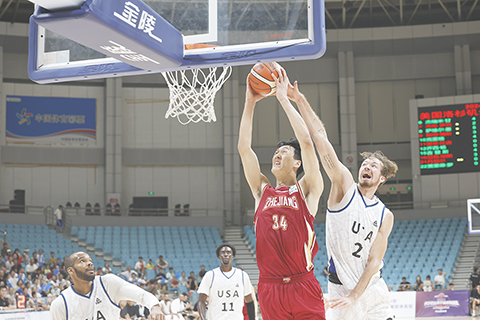 ◎ 八月二十一日,浙江舟山,中外職業男子籃球挑戰賽第二個比賽日,美國洛杉磯金沙灘隊八十九比六十八戰勝浙江稠州金租隊。圖為浙江稠州金租隊球員劉雙語(紅)在比賽中灌籃。(中新社記者 蕭健 攝)