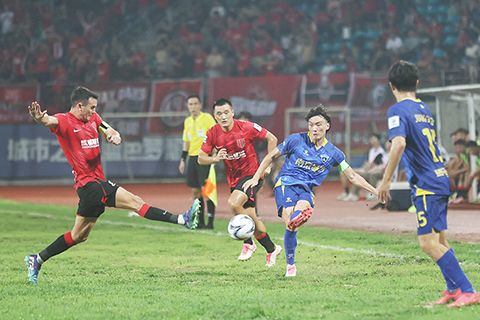 ◎ 八月二十一日晚,在江蘇南京五台山體育場進行的二0二四中國足球協會杯第六輪比賽中,成都蓉城隊(紅衣)客場二比一戰勝南京城市隊(藍衣),晉級四強。圖為南京城市隊球員楊賀(右二)在比賽中傳球。(中新社記者 泱波 攝)