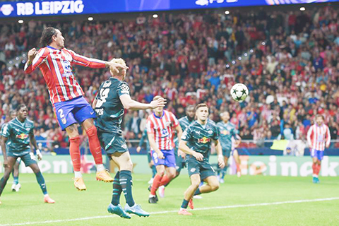 ◎ 馬德里體育會球員基文尼斯(上)在比賽中頭球得分。西甲馬體會主場二比一戰勝德甲萊比錫隊。(新華社發)