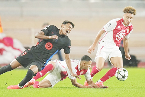 ◎ 巴塞入球功臣耶馬(左)昨役遭摩納哥隊重點照顧。(美聯社)