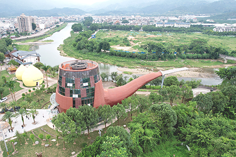 ◎ 形似煙斗型的建築外牆裝修已完成,周邊有兩個柚子形狀的大建築,格外醒目。(無人機照片)(中新社記者 呂明攝)