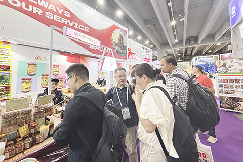 ◎ 十月卅一日,澳門展館的特色美食吸引採購商駐足品嚐。(中新社記者孫秋霞 攝)