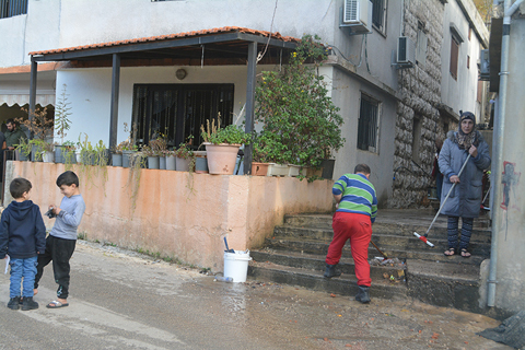 ◎ 黎巴嫩真主黨與以色列達成的停火協議當地時間十一月二十七日凌晨生效,部份逃離戰火的黎巴嫩民眾開始返回家園。圖為二十九日,在黎巴嫩拉斯艾因,人們在街道旁清掃台階。(新華社發塔希爾.阿布.哈姆丹 攝)