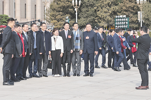 ◎ 三月四日上午,十四屆全國人大三次會議在北京人民大會堂舉行預備會議,通過了大會議程。圖為會議結束後,港區全國人大代表在會場外合影。(香港中通社記者 謝光磊 攝)