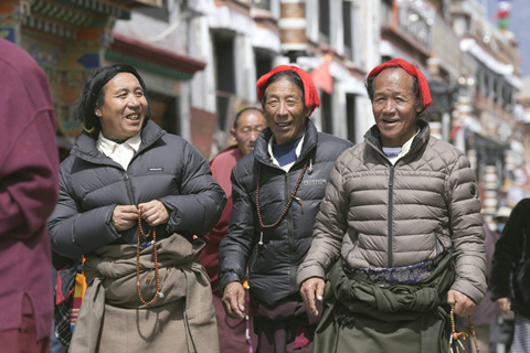 ◎ 三月十四日,信眾在八廓街轉經。三月的西藏拉薩,處處可見春的氣息。在布達拉宮腳下的宗角祿康公園,市民散步、跳鍋莊舞,在藥王山觀景台和八廓街等地,遊客遊覽拍照,各得其樂。(中新社記者 李林 攝)