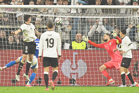 ◎ 三月二十三日,德國隊球員基連丁斯特(九號)頭球破門。德國隊主場三比三戰平意大利隊,以兩回合五比四的總比分晉級四強。(新華社發)