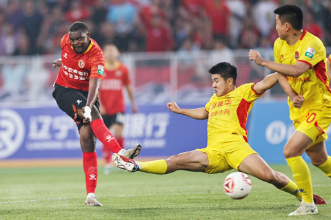 ◎ 六月十四日,中國足球甲級聯賽第十二輪比賽中,遼寧鐵人農商銀行隊主場三比零戰勝上海嘉定匯龍隊。圖為遼寧鐵人農商銀行隊球員姆本扎(左一)在比賽中射門。(中新社記者于海洋 攝)