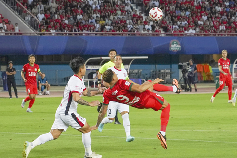 ◎ 六月十四日,中國足球超級聯賽第十四輪比賽中,河南俱樂部酒祖杜康隊主場三比二戰勝成都蓉城隊。圖為河南俱樂部酒祖杜康隊球員費利佩.卡多索(紅衣)在比賽中倒掛。(中新社記者范曉恒 攝)