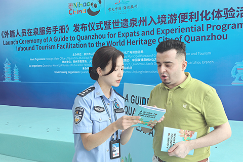 ◎ 六月二十日,福建泉州舉辦《外籍人員在泉服務手册》發佈儀式暨世遺泉州入境遊便利化體驗活動。圖為工作人員現場指導外籍旅客如何使用手册獲取實用信息。(中新社記者 孫虹 攝)
