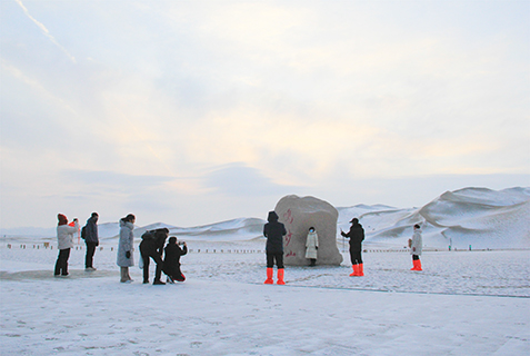 2024年12月10日,遊客在敦煌鳴沙山月牙泉景區觀賞大漠雪景。(王斌銀 攝)