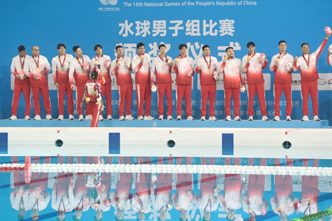 ◎ 十月二十七日晚,在廣東廣州舉行的第十五屆全國運動會水球男子組比賽金牌賽中,廣東隊以十六比九戰勝上海隊,獲得金牌。圖為廣東隊在頒獎儀式上向觀眾致謝。(中新社記者 陳楚紅 攝)